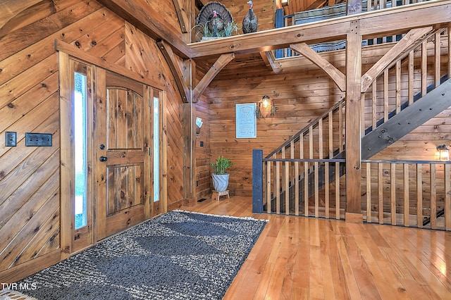 foyer with wood-type flooring and wooden walls