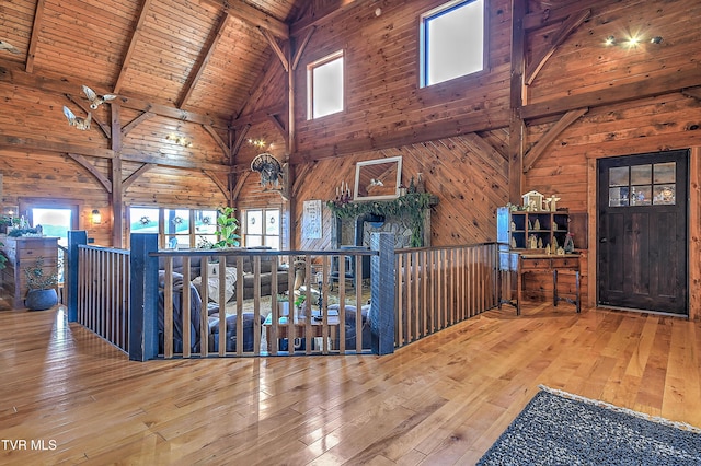 hall with wood ceiling, hardwood / wood-style flooring, beam ceiling, high vaulted ceiling, and wood walls