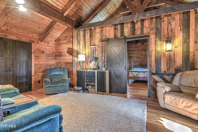 living room with wood walls, wood-type flooring, a barn door, wooden ceiling, and beam ceiling