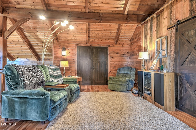 living room with wood-type flooring, lofted ceiling with beams, wooden ceiling, a barn door, and wood walls