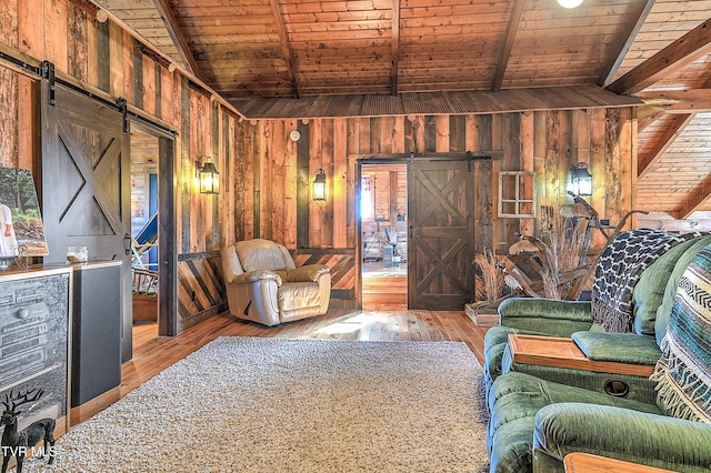 living room featuring hardwood / wood-style flooring, wooden ceiling, a barn door, and wood walls