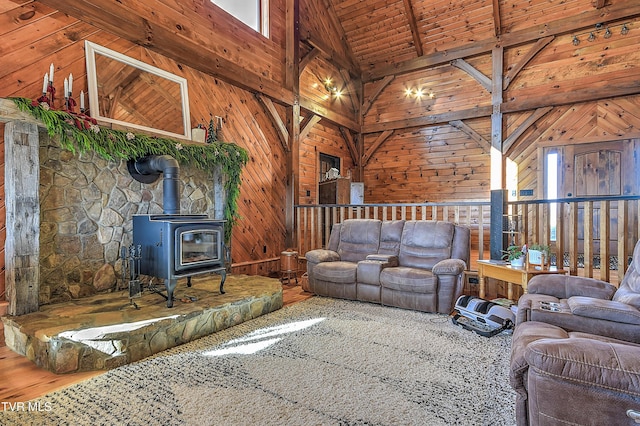 unfurnished living room featuring wooden walls, high vaulted ceiling, beamed ceiling, and a wood stove