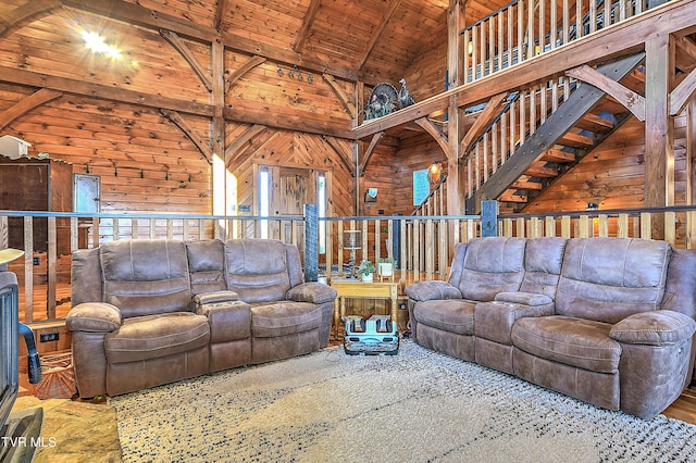 living room featuring beamed ceiling, high vaulted ceiling, wood ceiling, and wood walls