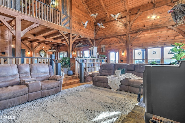 living room with wood ceiling, beamed ceiling, a healthy amount of sunlight, and wood walls