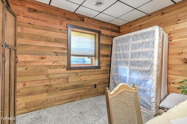 room details with carpet flooring, wooden walls, and a drop ceiling