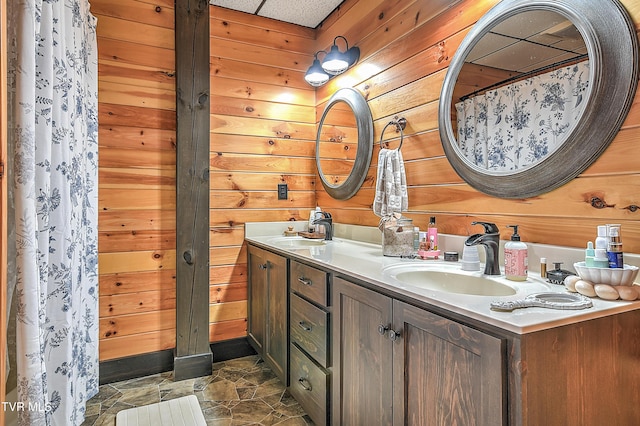 bathroom featuring vanity and wood walls