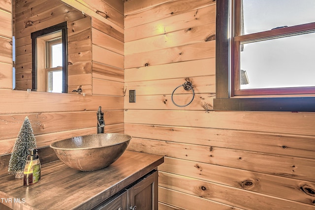 bathroom featuring vanity and wooden walls