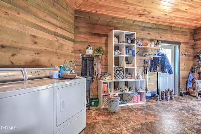 laundry room with wood ceiling, washer and dryer, and wood walls