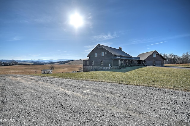 view of side of home featuring a mountain view and a lawn