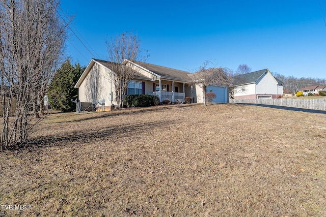 view of front of house featuring a garage, a front yard, and covered porch