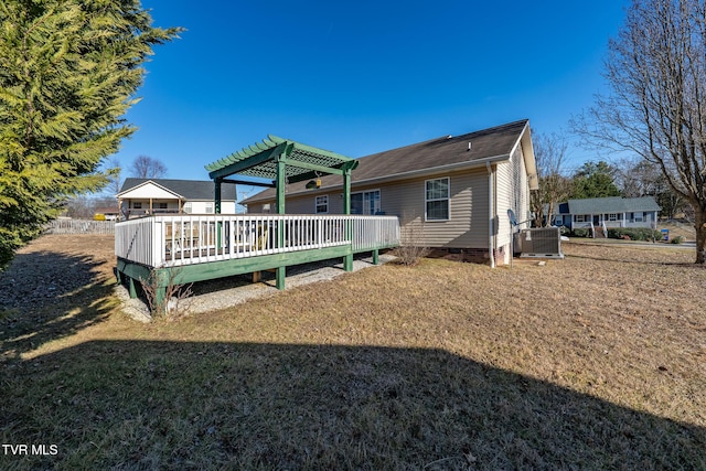 back of property featuring a wooden deck, a yard, a pergola, and central AC unit