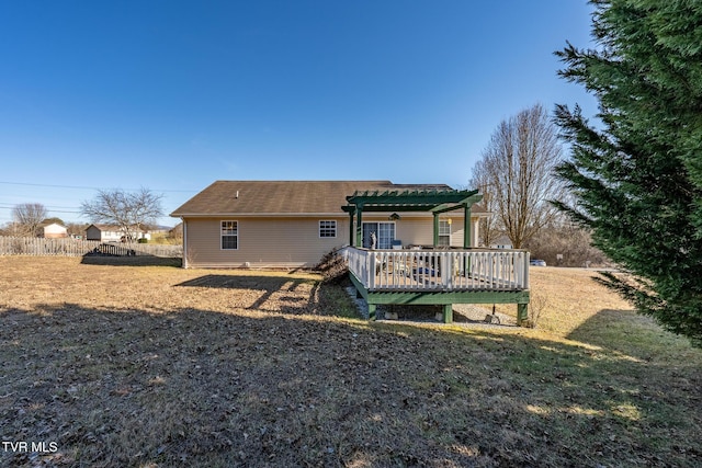 back of house featuring a pergola, a lawn, and a deck