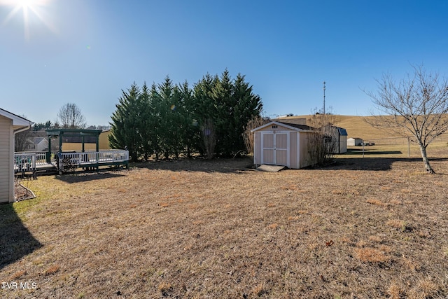 view of yard with a deck and a storage shed