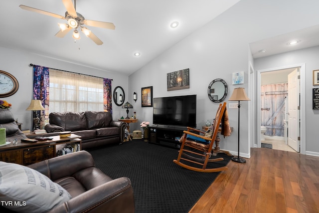 living room with ceiling fan, vaulted ceiling, and hardwood / wood-style floors