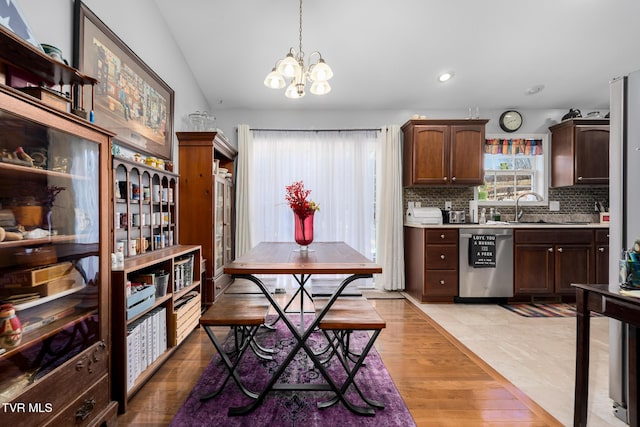 kitchen with dark brown cabinetry, tasteful backsplash, decorative light fixtures, light hardwood / wood-style flooring, and dishwasher