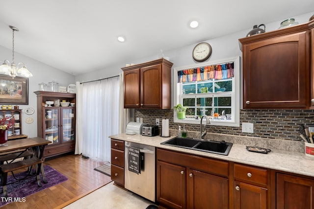 kitchen with sink, backsplash, hanging light fixtures, a healthy amount of sunlight, and stainless steel dishwasher