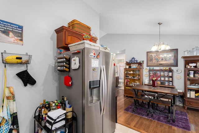 kitchen with vaulted ceiling, decorative light fixtures, a chandelier, hardwood / wood-style flooring, and stainless steel fridge with ice dispenser