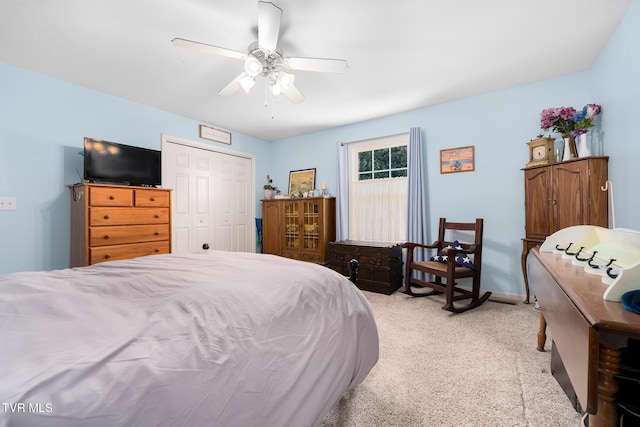 bedroom featuring light carpet, ceiling fan, and a closet