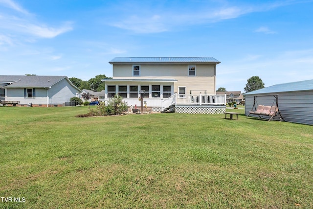 back of house featuring a wooden deck, a sunroom, central AC unit, and a lawn