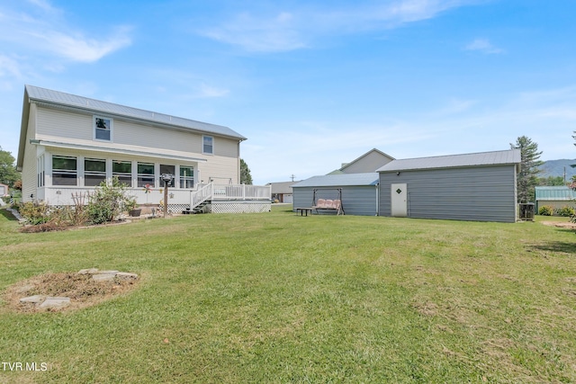 back of house featuring a deck and a lawn