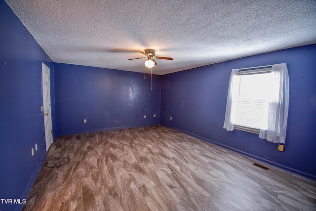 spare room featuring hardwood / wood-style flooring, ceiling fan, and a textured ceiling