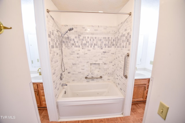 bathroom featuring vanity, tiled shower / bath combo, and a textured ceiling