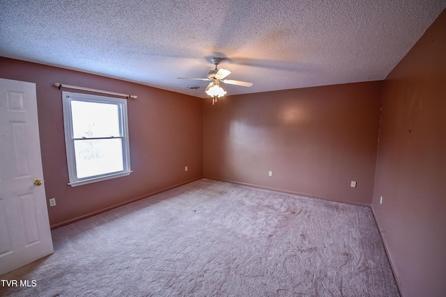 carpeted spare room with ceiling fan and a textured ceiling