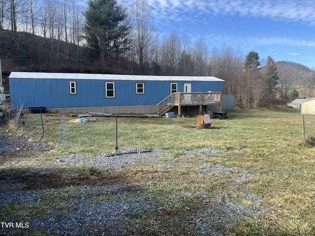 manufactured / mobile home with a front yard and a deck with mountain view