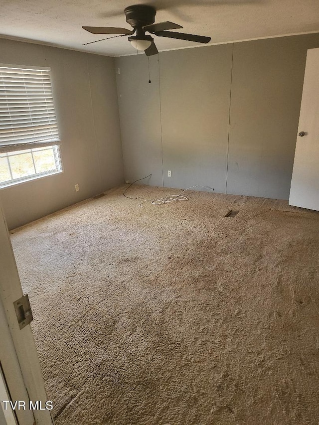 carpeted empty room featuring ceiling fan