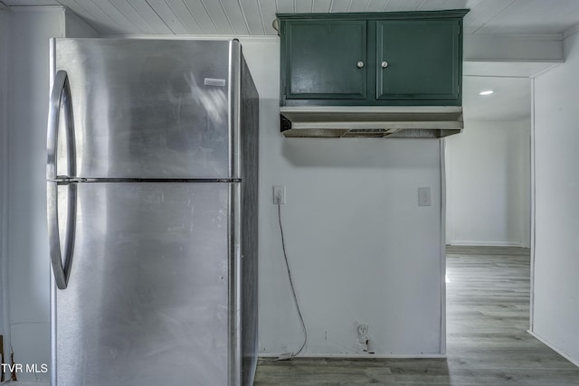 kitchen with green cabinetry, stainless steel fridge, and light hardwood / wood-style floors