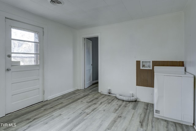 empty room featuring washer / dryer and light wood-type flooring