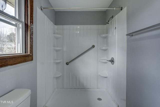 bathroom with a shower, a wealth of natural light, and toilet