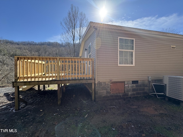 view of side of home featuring a wooden deck and central AC unit