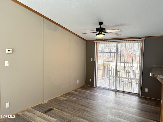 spare room featuring ceiling fan, ornamental molding, dark hardwood / wood-style floors, and a textured ceiling