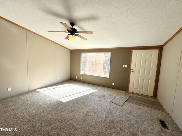 empty room with crown molding, carpet flooring, and a textured ceiling