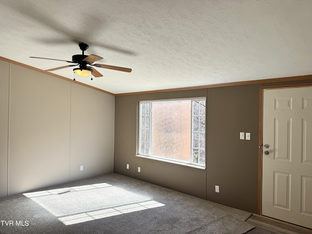 carpeted entrance foyer with crown molding, ceiling fan, vaulted ceiling, and a textured ceiling