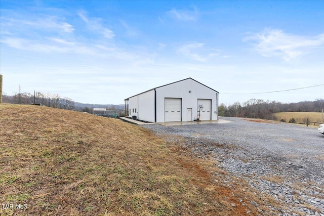 view of outdoor structure featuring a garage and a rural view