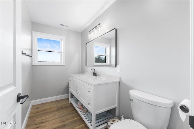 bathroom featuring wood-type flooring, toilet, and vanity