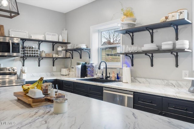 kitchen with stainless steel appliances, light stone countertops, and sink