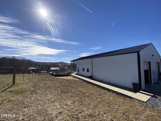 view of property exterior featuring a mountain view and an outdoor structure