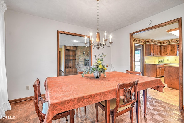 dining space featuring a chandelier, a textured ceiling, and light parquet floors