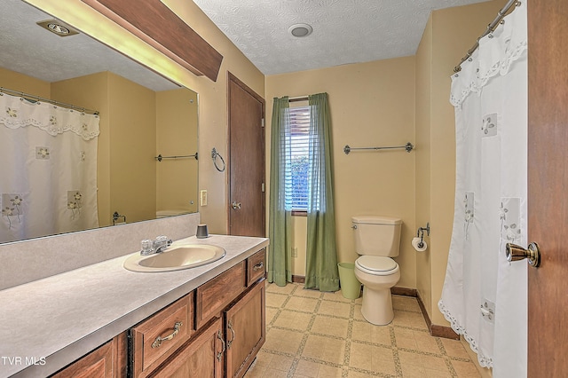 bathroom with vanity, a textured ceiling, and toilet