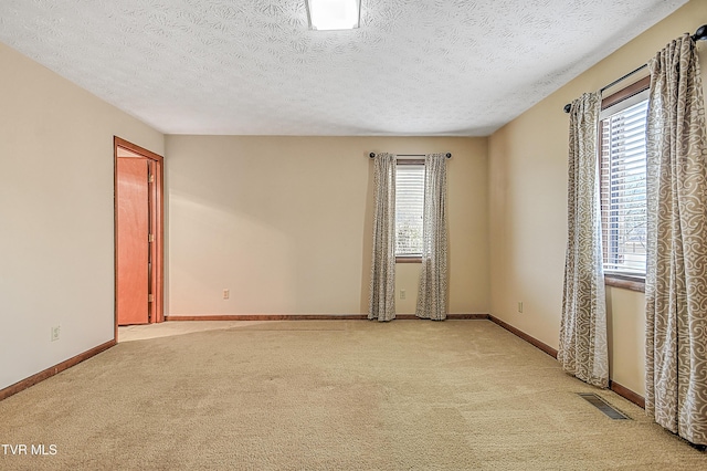 carpeted spare room with a textured ceiling