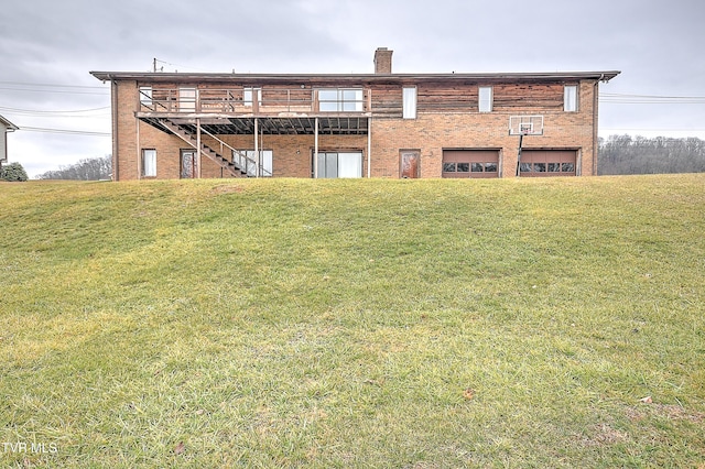 back of property featuring a garage, a yard, and a deck