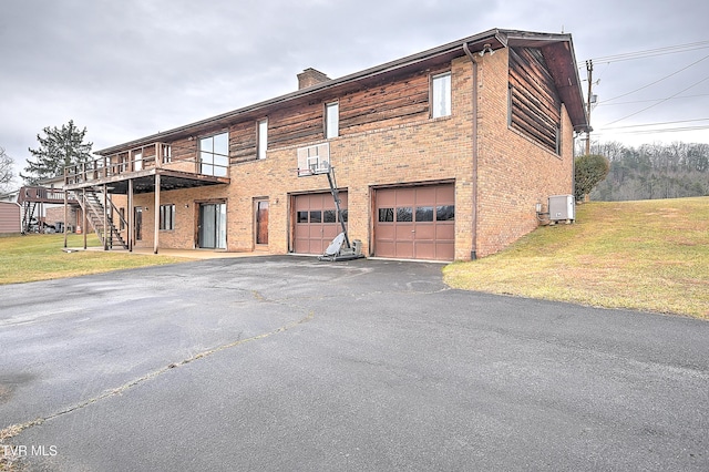 view of front of property with a garage, a front yard, and a deck