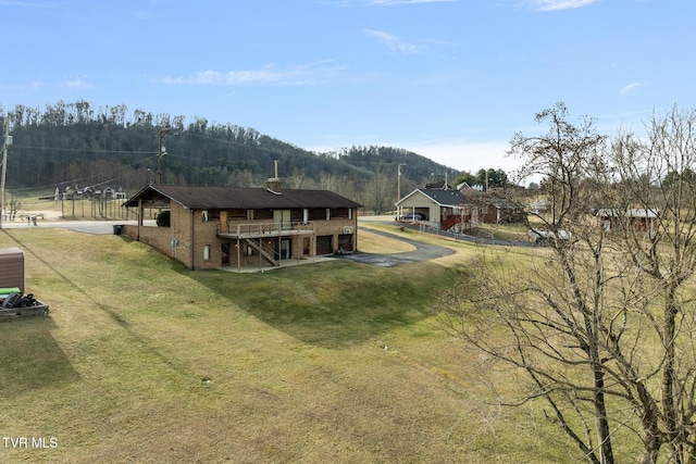 back of house featuring a wooden deck and a yard