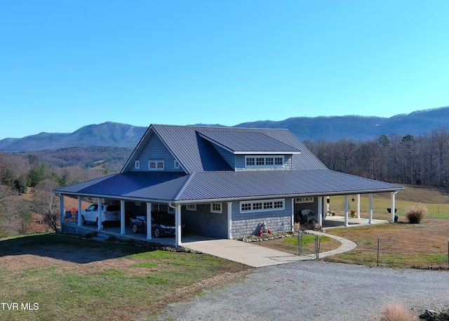 farmhouse inspired home with a garage, a mountain view, and a front lawn