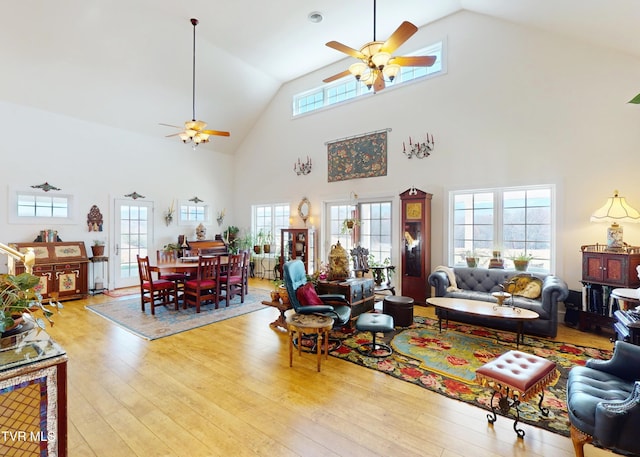 living room with ceiling fan, high vaulted ceiling, and light hardwood / wood-style floors