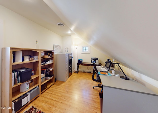 office space featuring lofted ceiling and light hardwood / wood-style flooring