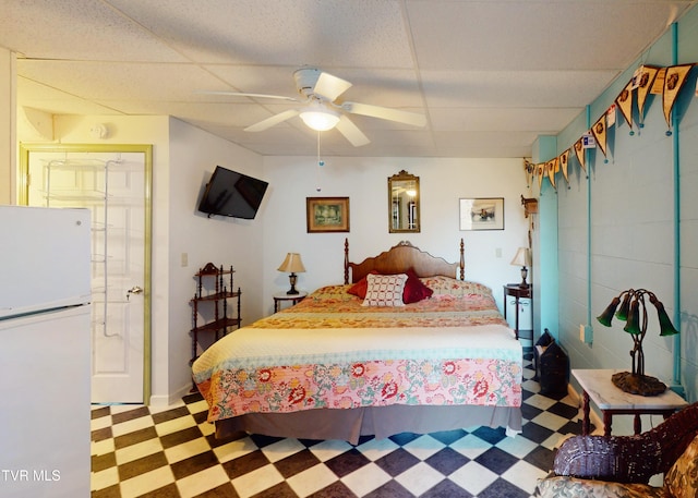 bedroom featuring white fridge, a paneled ceiling, and ceiling fan